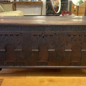 Carved oak Dutch coffer with triple panels surrounded by raised carved name ‘HANS PETER WESTERMANN ANNO 1627’. Cast metal carry handles on turned feet, castors are later. Some replacement screws and minor damage, consistent with age
