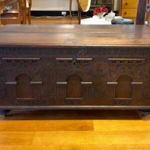 Carved oak Dutch coffer with triple panels surrounded by raised carved name ‘HANS PETER WESTERMANN ANNO 1627’. Cast metal carry handles on turned feet, castors are later. Some replacement screws and minor damage, consistent with age